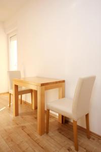 uma mesa de madeira com uma cadeira branca e uma mesa e cadeira de madeira em Apartment Duce 9437g em Dugi Rat