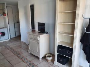 a room with a closet with a tv on a dresser at Aigue Marine. in Canet-en-Roussillon
