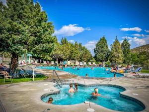 a group of people in the swimming pools at a resort at Aspen Retreat - Meredith Lodging in Redmond