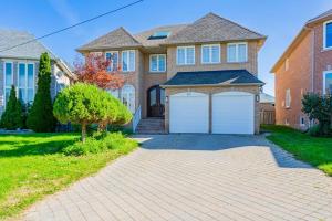 una casa de ladrillo con dos puertas blancas de garaje en Luxurious Spacious Dream Home, en Richmond Hill