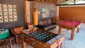 uma sala de estar com uma mesa de pingue-pongue e uma mesa de pingue-pongue em Nosso Recanto Gaúcho Paraíso no interior Guaratinguetá Aparecida em Guaratinguetá