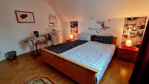a bedroom with a bed and a desk and a table at Pension Transilvania in Immendingen