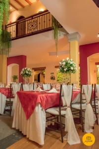 Hotel Spa Mansion Santa Isabella في ريوبامبا: غرفة طعام مع طاولات وكراسي مع ورود