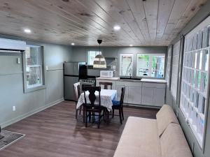 - une cuisine et une salle à manger avec une table et un canapé dans l'établissement Camp Hudson Pines, à Corinth