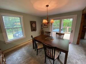 a dining room with a wooden table and chairs at Dog friendly Chalet in the Woods w/Pool-Mt. Snow in Wilmington