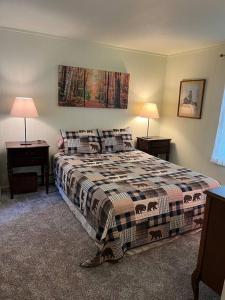 a bedroom with a bed with two tables and two lamps at Dog friendly Chalet in the Woods w/Pool-Mt. Snow in Wilmington