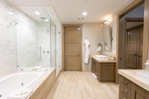 ein Bad mit einer Badewanne, 2 Waschbecken und einer Dusche in der Unterkunft Premium Junior Three Bedroom apartment hotel in Park City + 2 Fotos