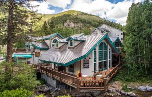 a house with a deck in the woods at Alpine Village Suites in Taos Ski Valley