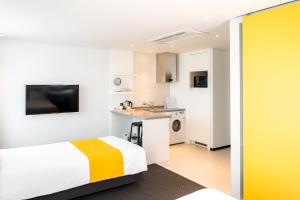 a hotel room with a bed and a kitchen at Seogwipo Hills Hotel in Seogwipo