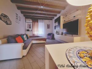 a living room with a couch and a flat screen tv at pitrè holiday house in Palermo