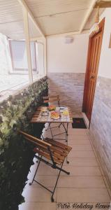 una habitación con bancos y una mesa con comida. en pitrè holiday house en Palermo