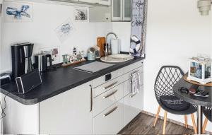 a kitchen with a black counter top and a table at Cozy Ship In Havelsee Ot Ktzkow With Kitchen in Kützkow