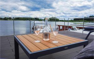 two wine glasses sitting on a wooden table on a boat at Cozy Ship In Havelsee Ot Ktzkow With Kitchen in Kützkow