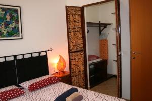 Dormitorio con espejo, cama y lámpara en Casa Bahia 5, en Santa Maria
