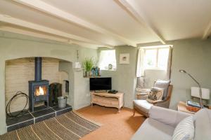 ein Wohnzimmer mit einem Kamin und einem Sofa in der Unterkunft Elworthy Cottage in Salcombe