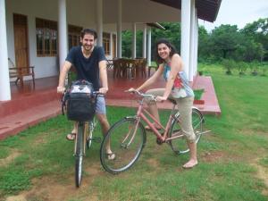 a man and a woman standing next to a bike at Ruins Villa in Polonnaruwa