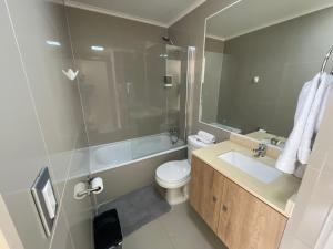 a bathroom with a toilet and a sink and a shower at Departamento Chillan céntrico in Chillán
