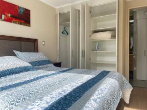 a bedroom with a blue and white bed and a closet at Departamento Chillan céntrico in Chillán