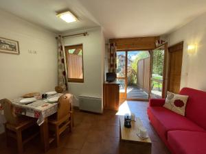 een woonkamer met een rode bank en een tafel bij Appartement Praz-sur-Arly, 1 pièce, 4 personnes - FR-1-603-63 in Praz-sur-Arly