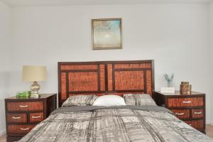 ein Schlafzimmer mit einem großen Holzbett mit zwei Nachttischen in der Unterkunft CHARMING 4 BEDROOMS BROOKSHIRE/KATY WITH GYM in Brookshire