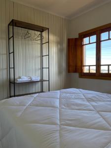 1 cama blanca grande en un dormitorio con ventana en Casa Vita BG - Casa de campo en Bento Gonçalves