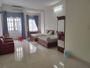 a living room with two beds and a mirror at Homestay 846/B53 in Vung Tau