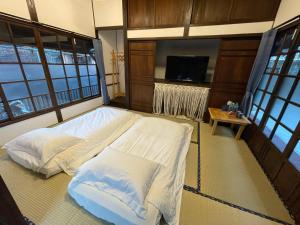 1 Schlafzimmer mit 2 Betten in einem Zimmer mit Fenstern in der Unterkunft 南庄東村宿舍Nanzhuang Dongchon Homestay in Nanzhuang
