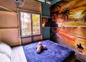 um quarto com um bicho de peluche numa cama com uma janela em Hidden Jungle Beach House em Puerto Viejo