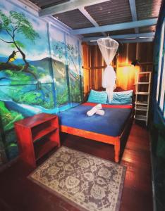 1 dormitorio con una pintura en la pared en Hidden Jungle Beach House, en Puerto Viejo