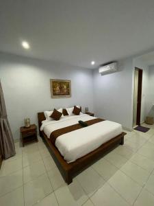 a bedroom with a large bed in a room at Canggu Nadi Guest House in Canggu