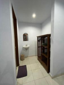 a bathroom with a sink and a mirror and a toilet at Canggu Nadi Guest House in Canggu
