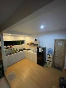 a kitchen with white cabinets and a wooden floor at Canggu Nadi Guest House in Canggu