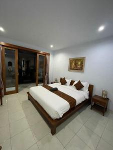 a bedroom with a large bed in a room at Canggu Nadi Guest House in Canggu