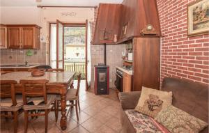 サンタンブロージョ・ディ・トリーノにあるBeautiful Home In Santambrogio Di T, With Wifiのレンガの壁、ダイニングテーブル付きのキッチンが備わります。