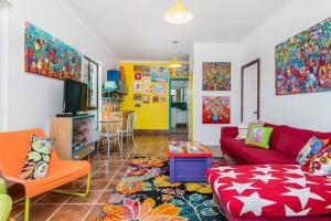 sala de estar con sofá rojo y habitación colorida en Donna's Art House, en Alstonville