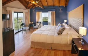 Schlafzimmer mit einem Kingsize-Bett und einem Balkon in der Unterkunft Melodias Posada Boutique in Los Reartes