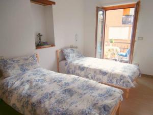 two beds in a room with a window at B&B della Contrada Varenna in Varenna