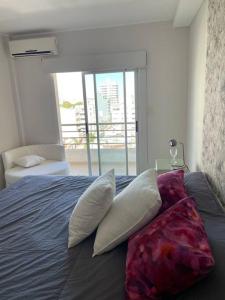 a bedroom with a bed with pillows and a window at Corrientes Pora in Corrientes