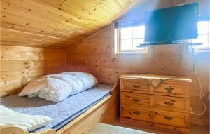 a bedroom with a bed in a wooden cabin at 5 Bedroom Awesome Home In Lillehammer in Lillehammer