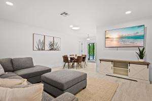 ein Wohnzimmer mit einem Sofa und einem TV an der Wand in der Unterkunft Your private tropical paradise with heated pool! in Sarasota