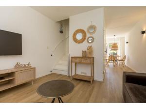 uma sala de estar com uma televisão e uma mesa em Quietly located house within walking distance of the beach em Domburg