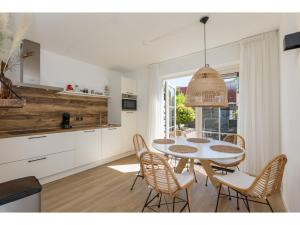 uma cozinha e sala de jantar com mesa e cadeiras em Quietly located house within walking distance of the beach em Domburg