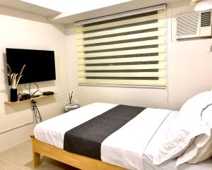 Un dormitorio con una cama grande y una ventana en Nordic Bleu Staycation at Ayala Serin, en Tagaytay