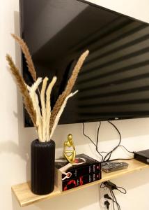 a black vase with feathers in it sitting on a shelf at Nordic Bleu Staycation at Ayala Serin in Tagaytay