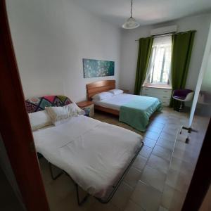 ein Hotelzimmer mit 2 Betten und einem Fenster in der Unterkunft Astra House relax a 10minuti da Salerno centro in Pellezzano