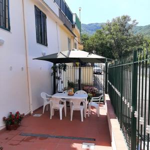 eine Terrasse mit einem Tisch, Stühlen und einem Sonnenschirm in der Unterkunft Astra House relax a 10minuti da Salerno centro in Pellezzano