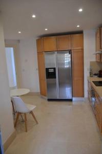 uma cozinha com um frigorífico de aço inoxidável e uma mesa em Lovely 2 bedroom unit with private pool em Sotogrande