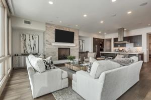 sala de estar con 2 sillas blancas y chimenea en Platinum Two Bedroom apartment hotel, en Park City