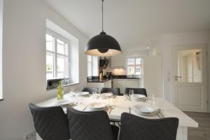 een eetkamer met een witte tafel en stoelen bij Haus Katharina links in Wyk auf Föhr