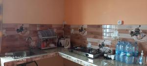 a kitchen with a sink and a counter with water bottles at Résidence Véronia -Couchée de Soleil Et Vue sur Mer in Rodrigues Island +49 photos